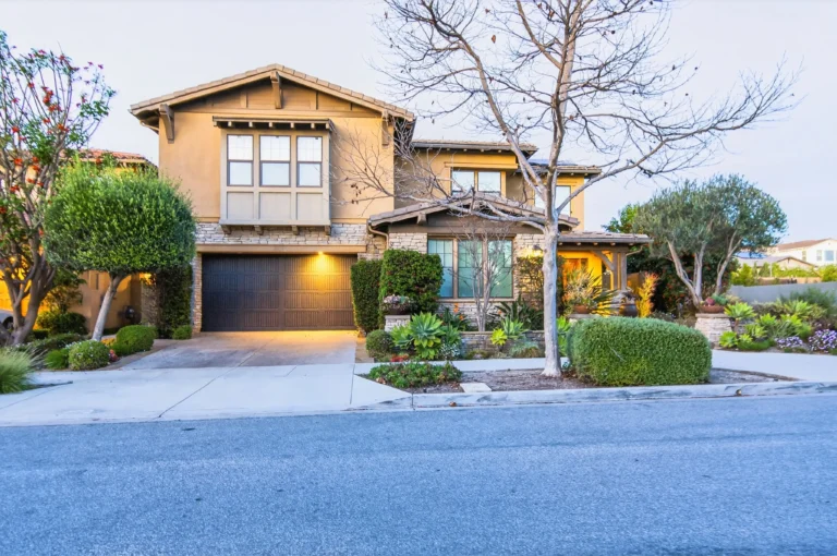 Exterior captured from driveway emphasizing garage and front landscaping