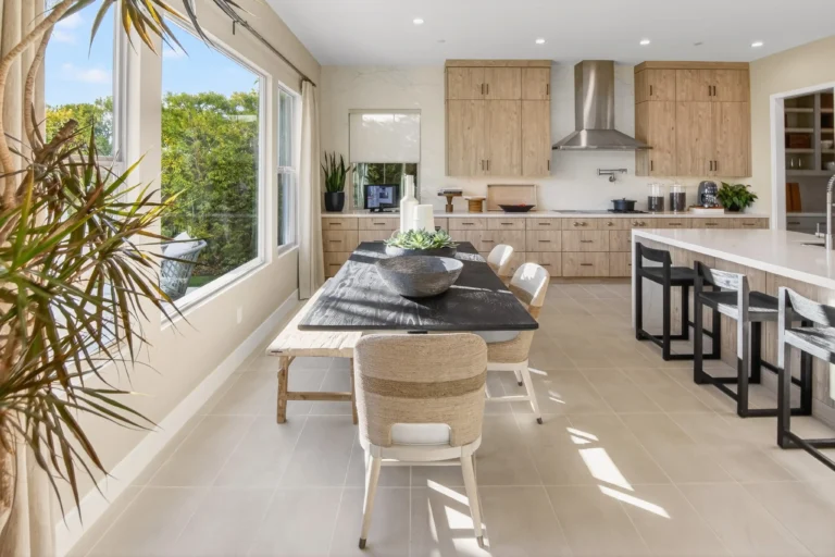 Bright dining room with large windows and neutral staged furniture