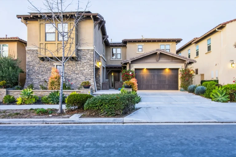 Driveway view showing garage doors, walkway and front yard landscaping