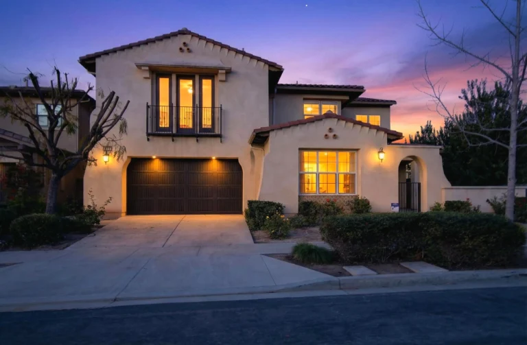Twilight exterior with warm interior lights and dramatic evening sky